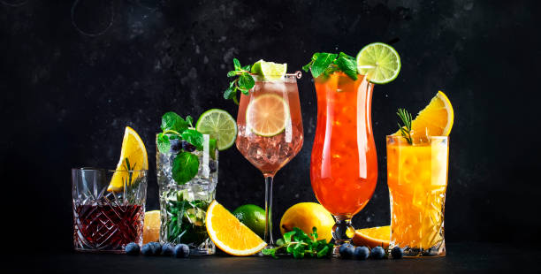 Popular summer cocktail drinks set: negroni, blueberry mojito, screwdriver, hurricane and french mule on black bar counter background, banner
